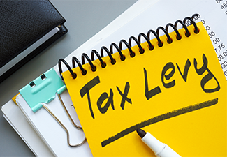 Stack of documents and notepad with inscription tax levy