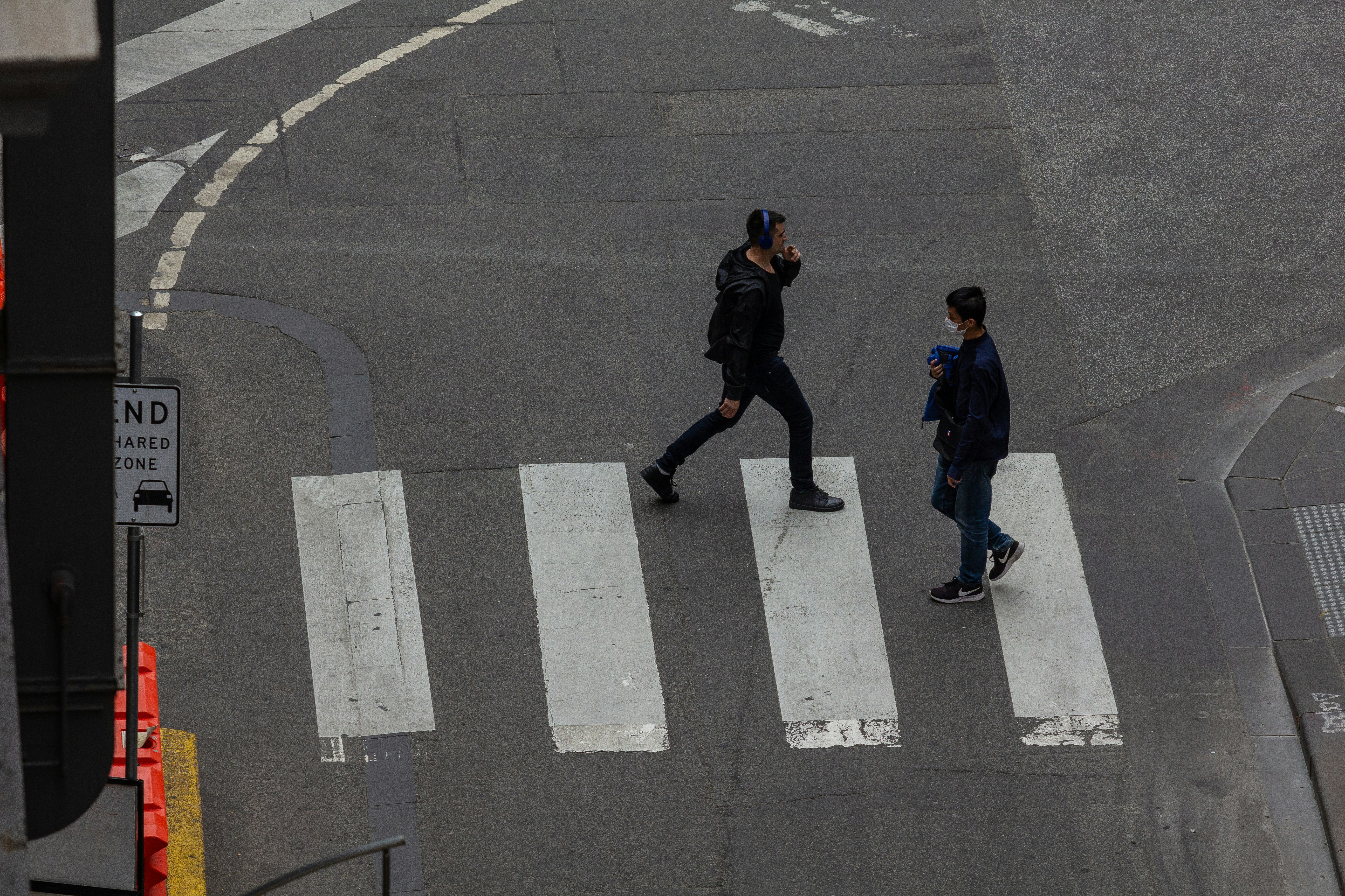 Two male pedestrians crossing the street in an intersection