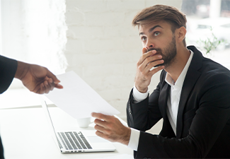 Frustrated shocked Caucasian male worker getting dismissal notice