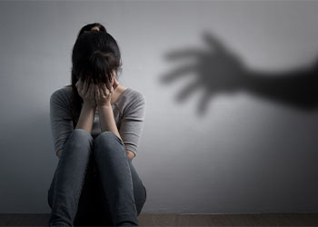 Crying women with lurking shadow of hand behind her