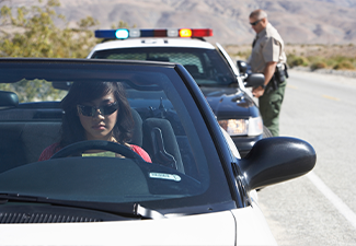 Women sitting in car being pulled over by police officer