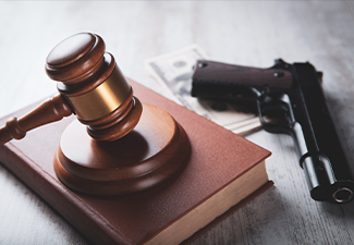 Court gavel with a gun on the table