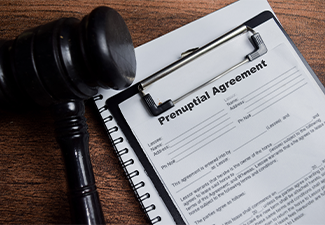 Concept of prenuptial agreement contract write on clipboard isolated on Wooden Table