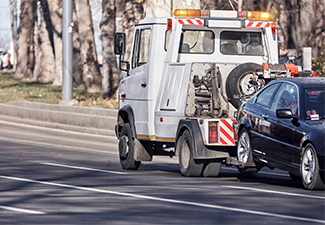Tow truck carrying improperly parked car or repossesed vehicle