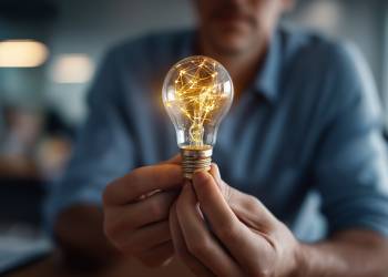 Hands holding glowing lightbulb