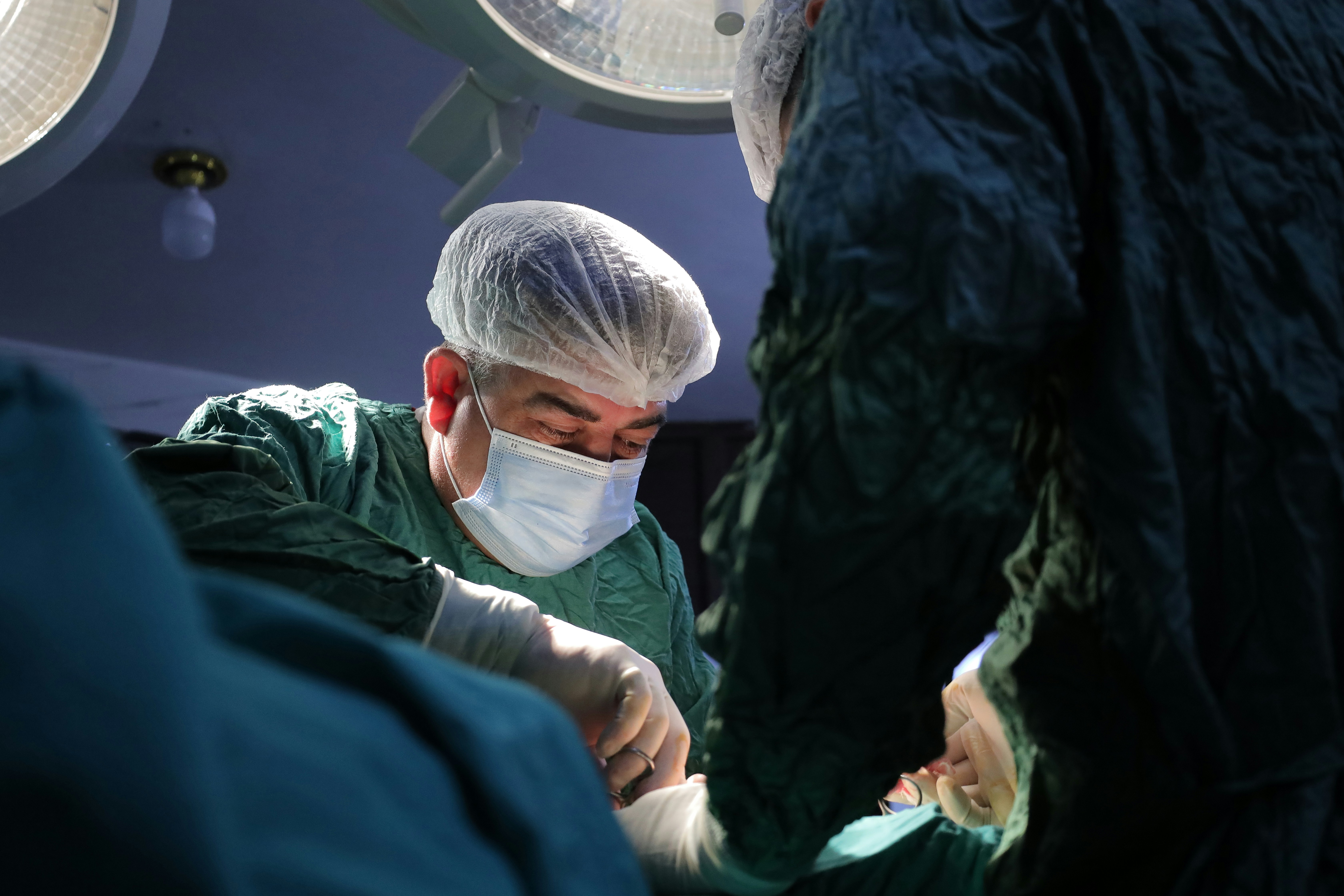 Focused male operating on a patient