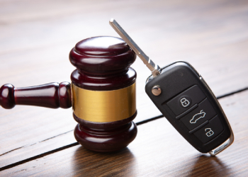 Car key and gavel in table