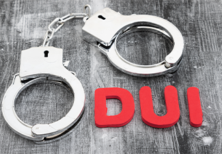 DUI message with silver handcuffs on weathered wood
