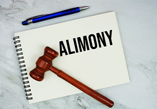 Alimony text written on notepad with pen and judge gavel on marble background