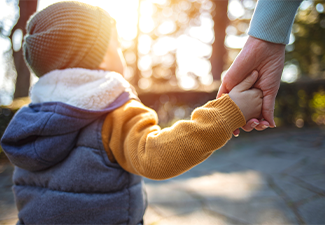 Close up of mother and a child hands at the sunset
