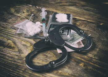 Drugs and handcuffs on table