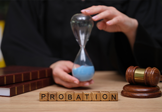 A judge holds an hourglass filled with blue sand, symbolizing time in a courtroom setting