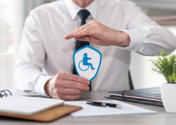 Man holding sign with disability person, concept of disability insurance