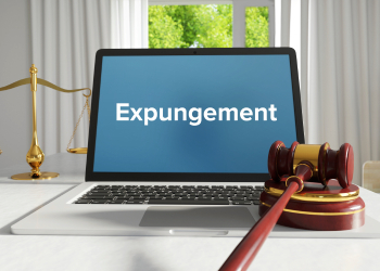 Expungement word on laptop screen with gavel in table