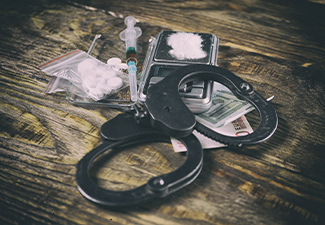 Illegal drugs, money and handcuffs on table