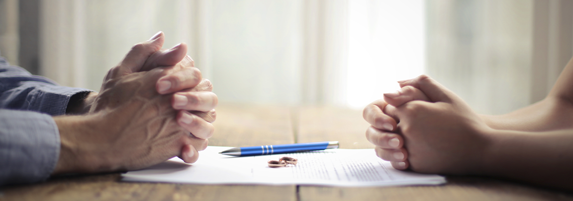 Man and Woman in Table discussing Divorce Contract