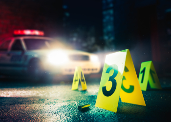 Police car at a crime scene with evidence markers