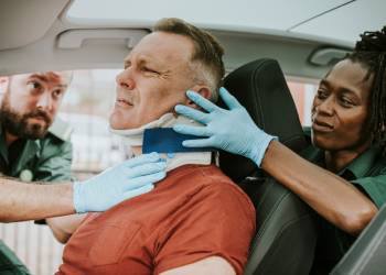 Paramedics helping an injured man after car accident