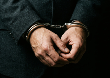 Handcuffed businessman in dark suit