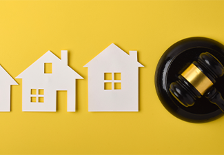 Judge gavel with house icons on yellow background