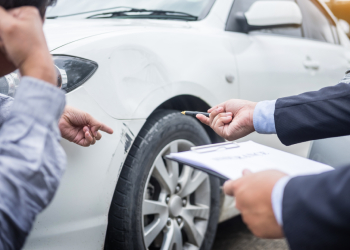 Insurance agent examining car after accident