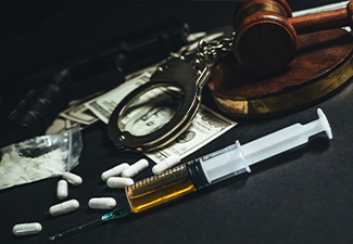 Gavel, Handcuff and drugs at the table