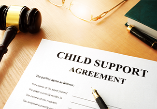 Document with the name child support agreement and gavel on the table