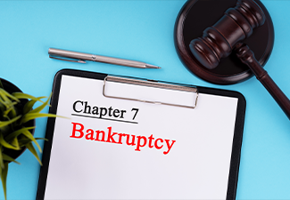 Clipboard with text Chapter 7 Bankruptcy and a Gavel on the Table