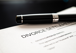 Divorce settlement agreement document with a sleek pen resting on top