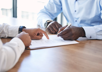Hands gesturing man to sign in a contract paper