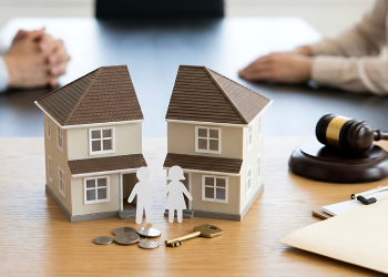 Split house model with paper couple and gavel on desk