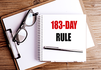 183 day rule concept with notebook text glasses and pen on wooden desk