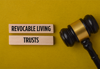 Legal estate planning concept featuring a gavel and blocks labeled Revocable Living Trusts