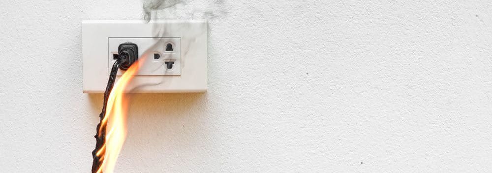 Power cord on fire and plugged into an outlet