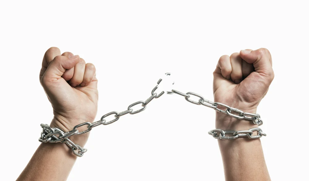 Hands breaking free of chains
