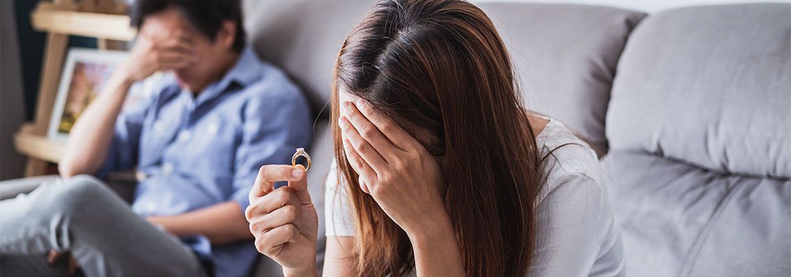 Frustrated sad wife taking off the wedding ring