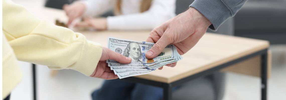 Man handing spousal support money to his ex-wife