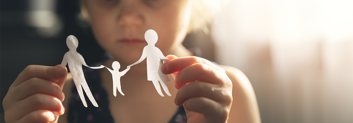 Little girl with paper family in hands