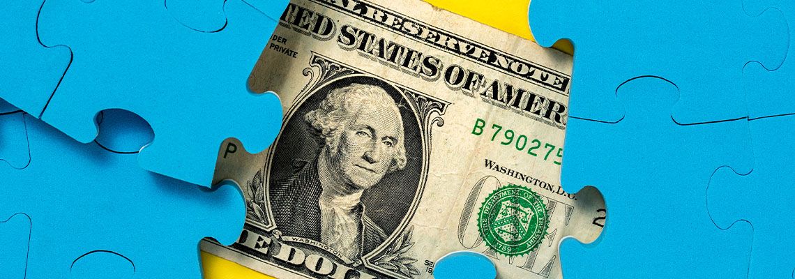 American Dollar hidden behind puzzle pieces