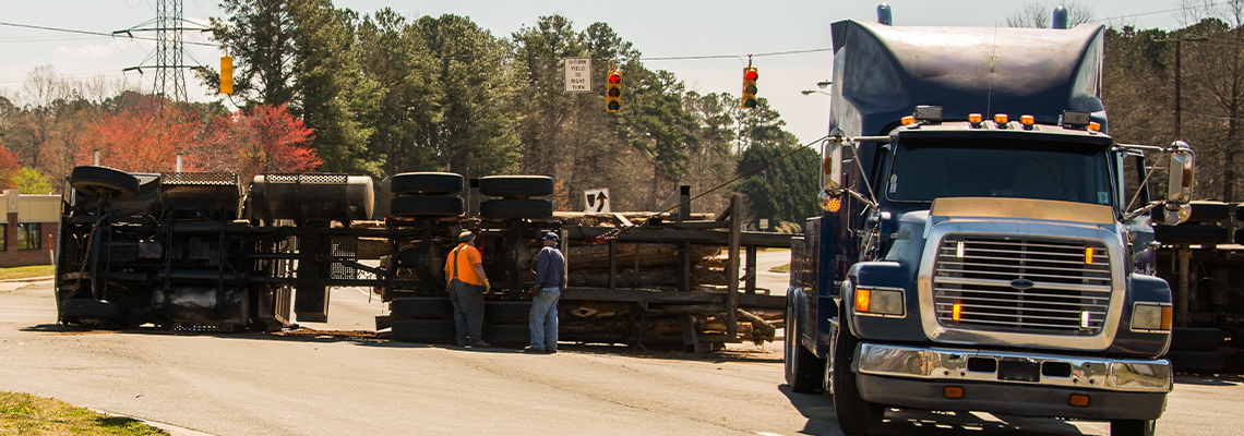 Logging truck turned over on highway
