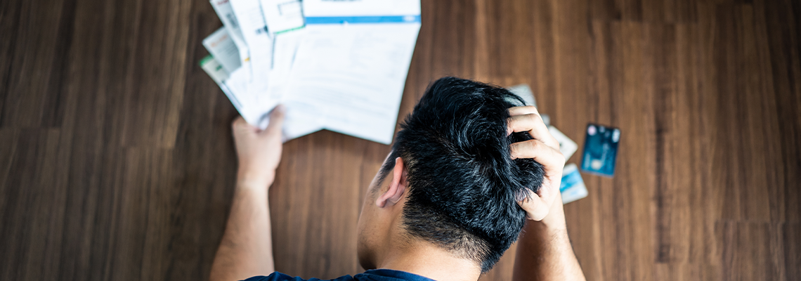 Top view of stressed young Asian man hands holding the head
