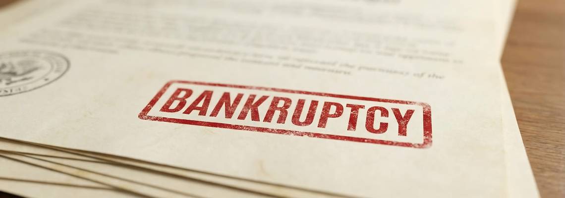 Close-up of documents stamped with bankruptcy on a wooden table