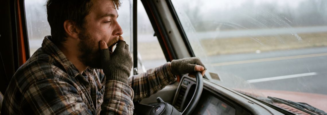 Tired truck driver yawning while driving on the road f