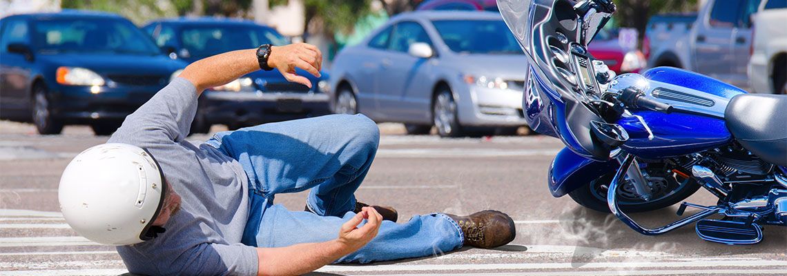 Man slides on road along with motorcycle after road accident