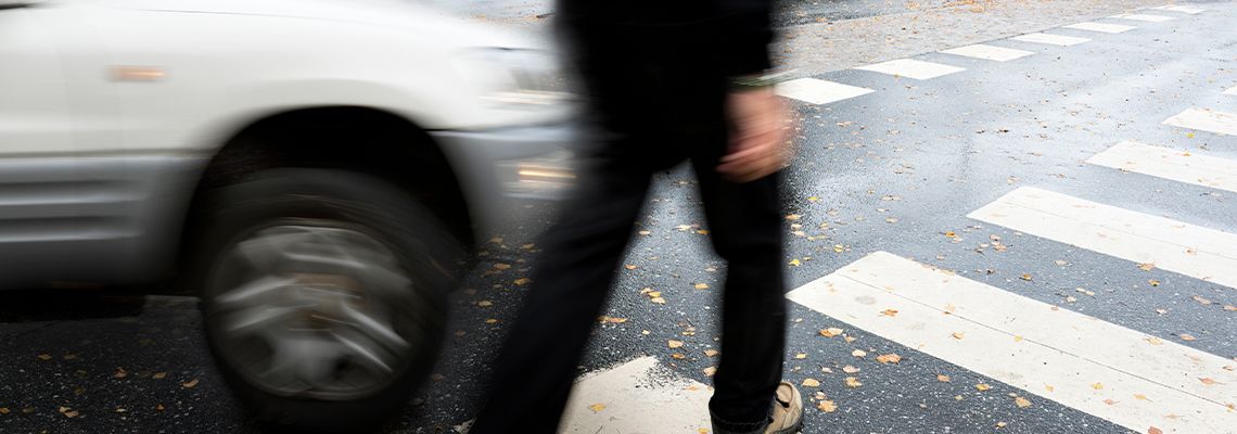 Car about to collide with pedestrian in road