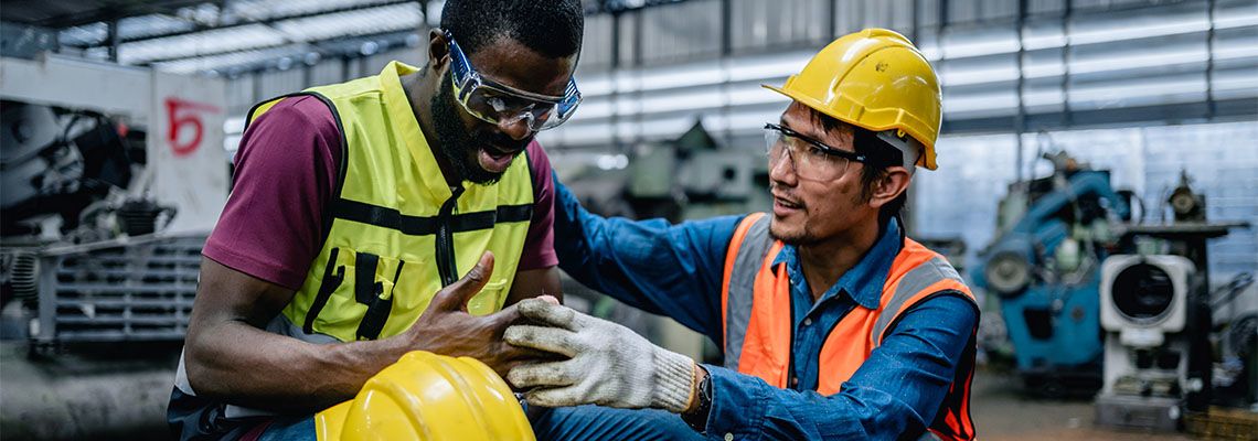Site engineer helping injured worker