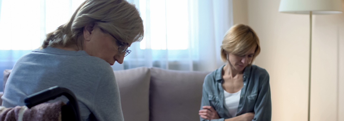 Elderly disabled mother talking with nurse