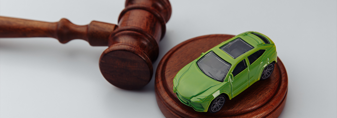 Green car and judge gavel on a white background