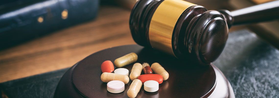 Judge gavel and drugs on a wooden desk