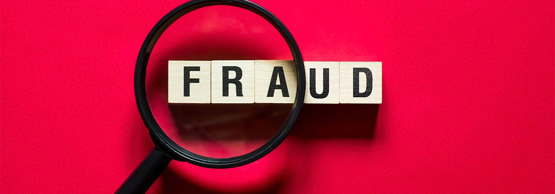 Fraud word under magnifying glass